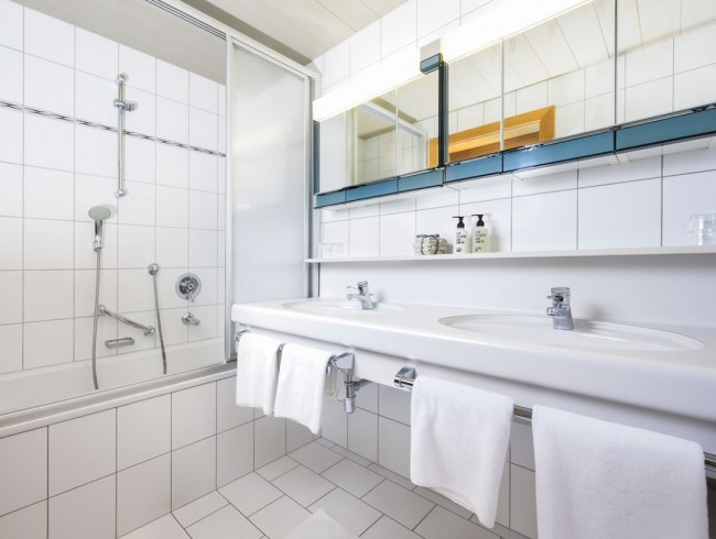 Badezimmer mit Doppelwaschbecken, Dusche und Badewanne - Gästehaus Kirchgasser in Filzmoos